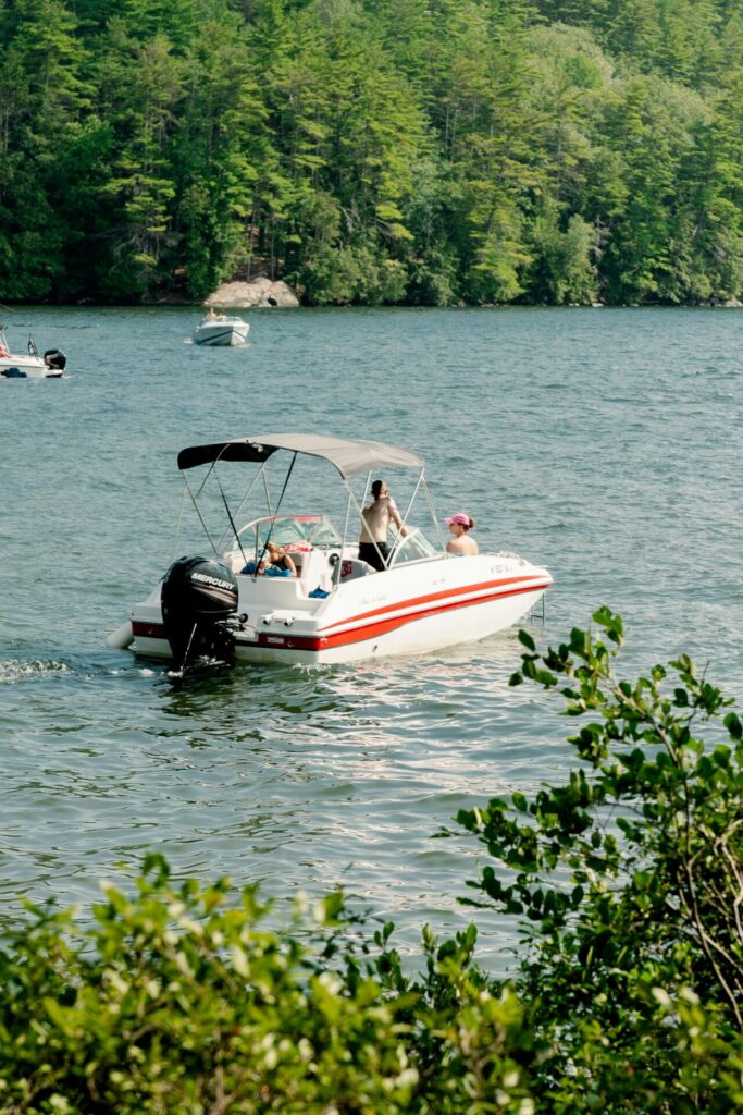 Family enjoying a boat ride on Broken Bow Lake surrounded by pine forests in Oklahom
