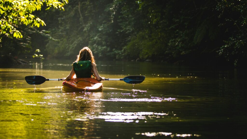Kayaker paddling through the calm waters of Broken Bow Lake in Oklahoma.