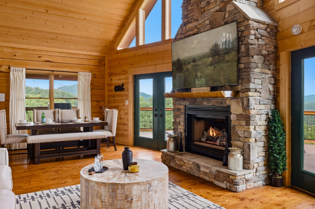 Open living room with stone fireplace and large windows at Bear Ridge Escape