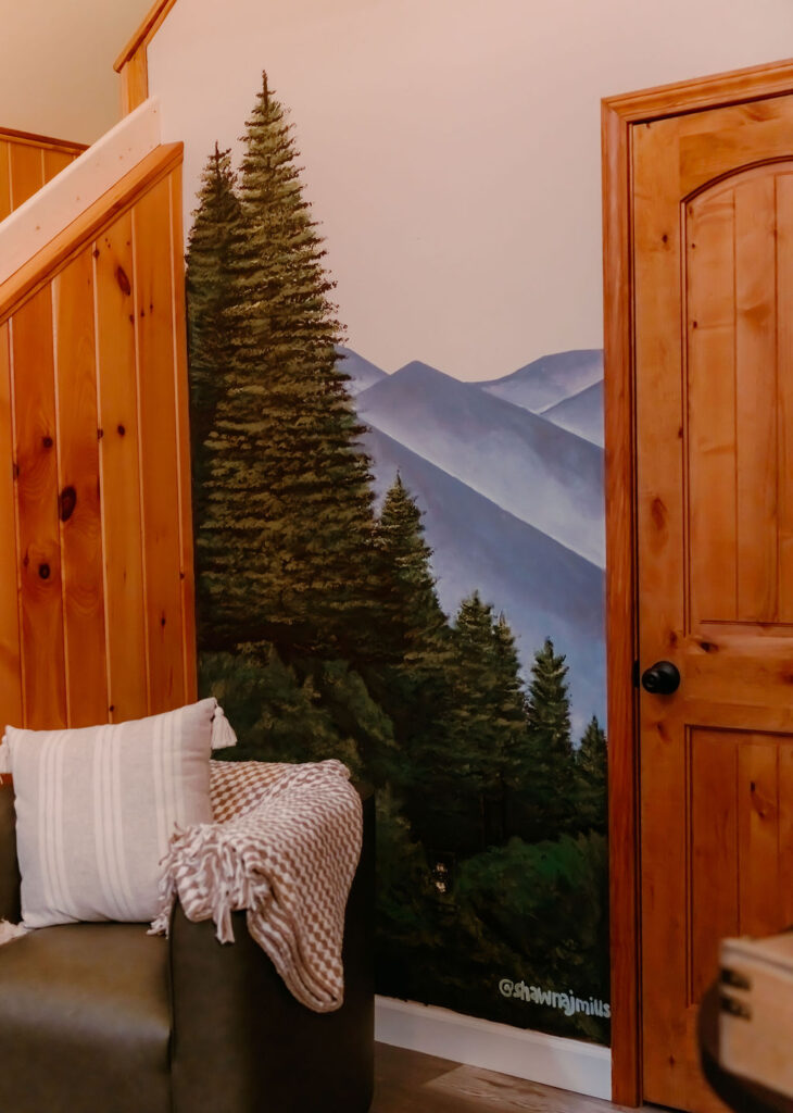 Mountain landscape artwork decorating the stairway of the Gatlinburg cabin.
