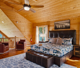 Spacious primary bedroom with king bed and vaulted wood ceilings at Bear Ridge Escape