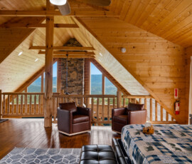 Primary suite with king bed, sitting area, and open loft at Bear Ridge Escape