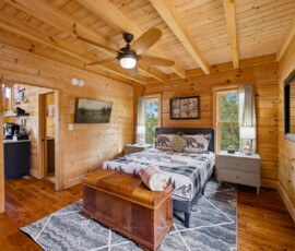 Cozy king bedroom with warm wood walls at Bear Ridge Escape