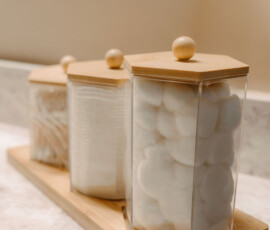 Decorative bathroom storage jars with cotton balls and cotton swabs.