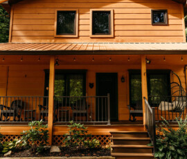 Welcoming front porch with wooden railings and seating at After the Trail cabin.