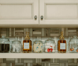 Coffee bar with flavored syrups, white cabinets, and tile backsplash at After the Trail cabin.