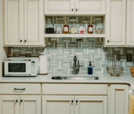 Bright white kitchen with cabinets, coffee station, and countertop appliances in the Gatlinburg cabin.