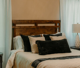 Close-up of cozy bedding and decorative pillows on the queen bed at After the Trail.